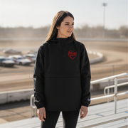 Woman wearing a black hoodie with a red racing daughter heart design at a race track.