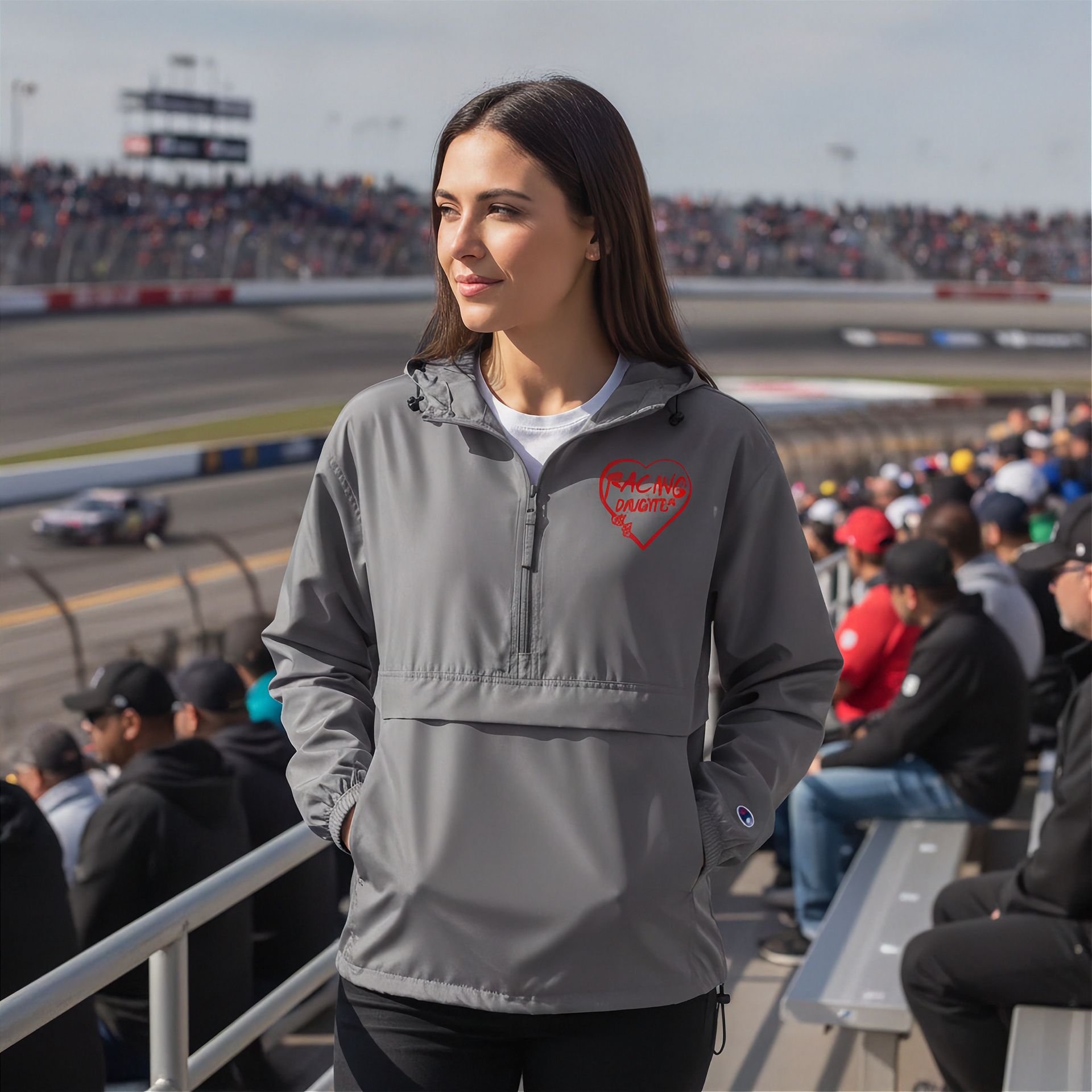 Woman in a gray jacket with a red racing daughter heart design at a race track event
