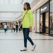 Woman in a bright green hoodie with a red racing daughter heart design walking in a shopping mall.