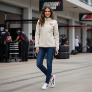 Woman in a white jacket with a red racing daughter heart design standing in a garage area with 'BRUNI' branding.