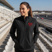 Woman wearing a black jacket with a red racing daughter heart design at a race track.