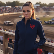 Woman in a dark blue jacket with a red racing daughter heart design at a race track.
