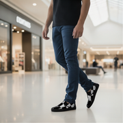 Man wearing blue pants and black checkered shoes in a mall setting