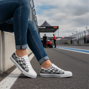 Person wearing checkered sneakers on a race track with a blurred background