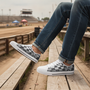 Person wearing checkered sneakers with a race track in the background