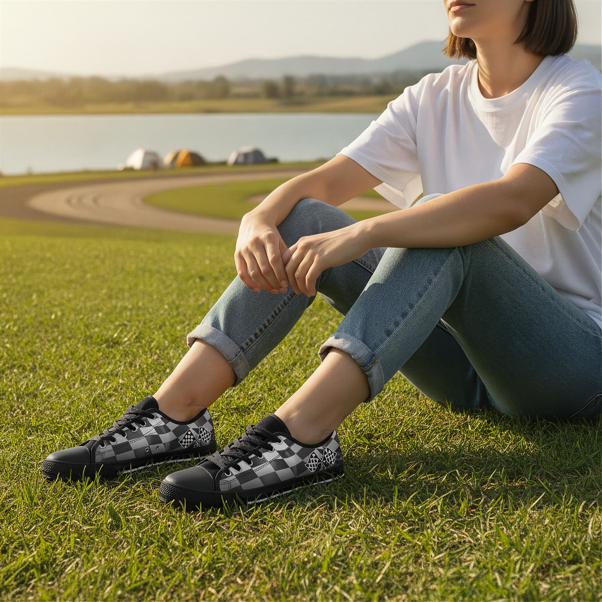 Person sitting on grass wearing checkered shoes with a scenic background