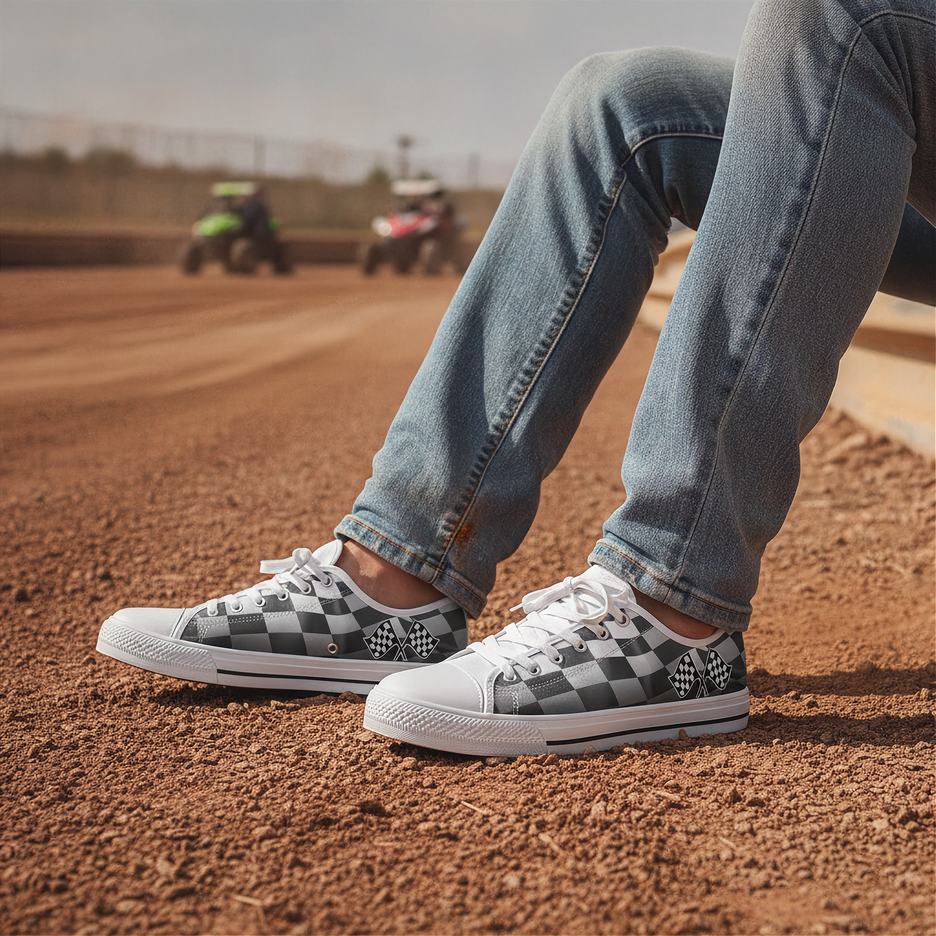 Person wearing checkered shoes on a dirt track with ATVs in the background