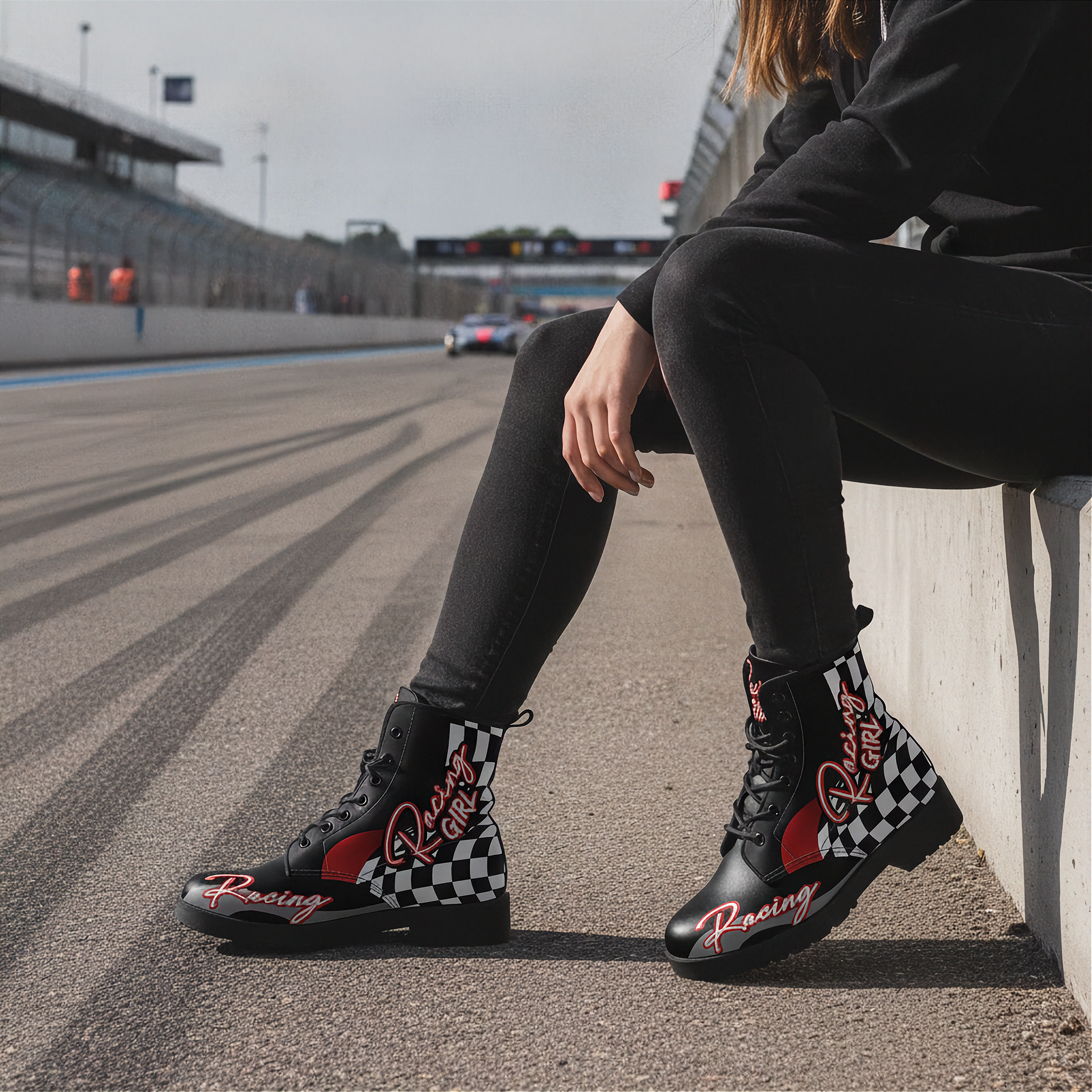 woman wearing checkered boots with racing design on a race track.