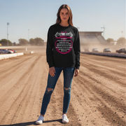 Woman wearing a black sweatshirt with racing graphics on a dirt track.