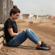 Woman sitting on a track wearing racing shoes with a checkered pattern