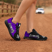 Black and purple racing girl shoes with checkered patterns on a dirt road.