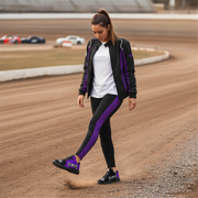 Woman walking on a dirt track wearing a black and purple outfit with a white shirt and a racing girl purple shoes