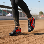 woman at a dirt track wearing a racing girl sneakers in red and black