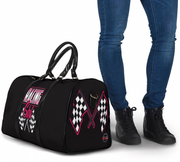 Black duffel bag with racing design next to a person wearing blue jeans and black shoes.