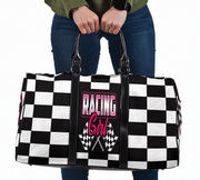 Woman holding a travel bag with a pink racing girl and checkered flag design with a white background