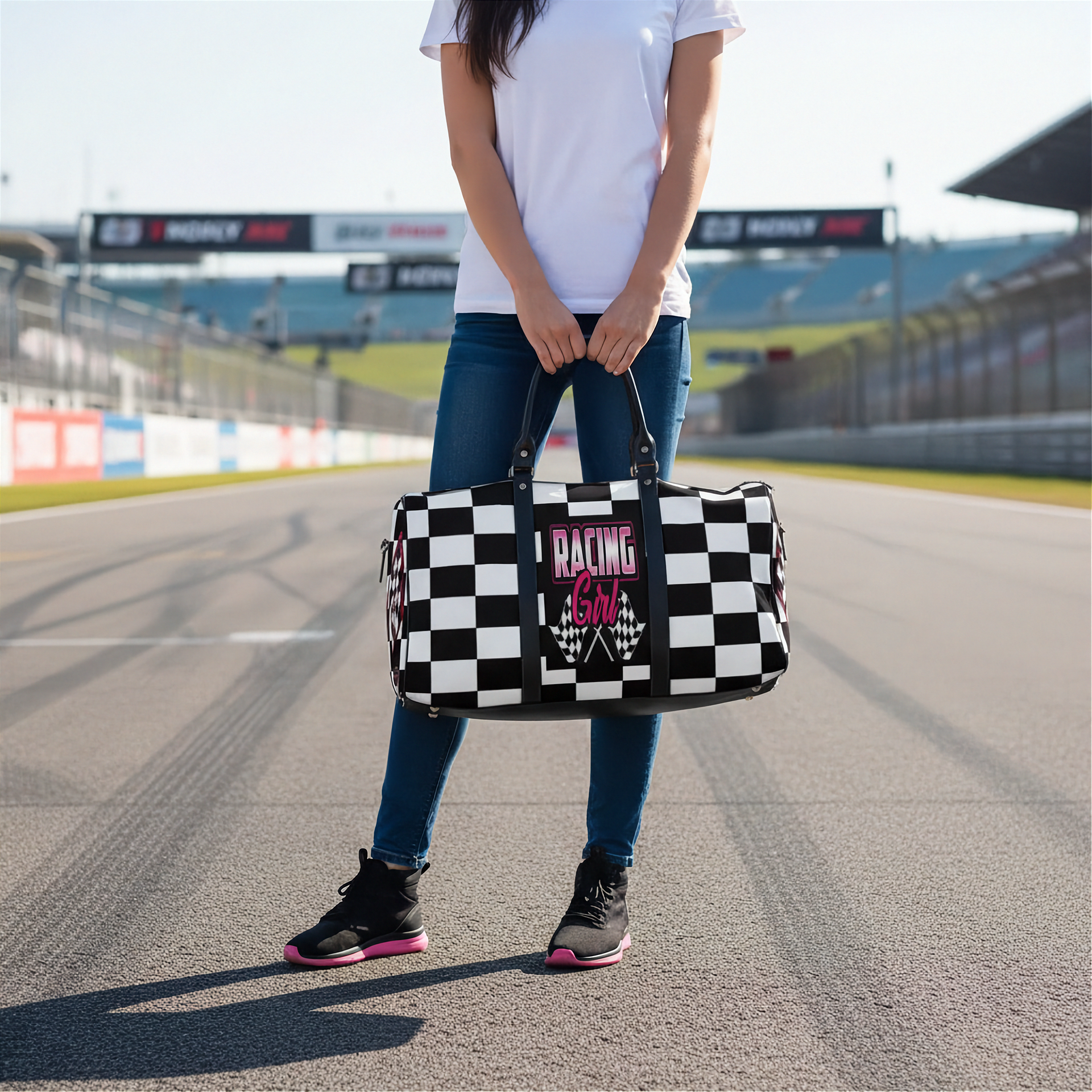 Woman holding a travel bag with a pink racing girl and checkered flag design at a race track, customizable text.