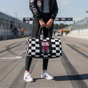 Woman holding a travel bag with a pink racing girl and checkered flag design, customizable text.