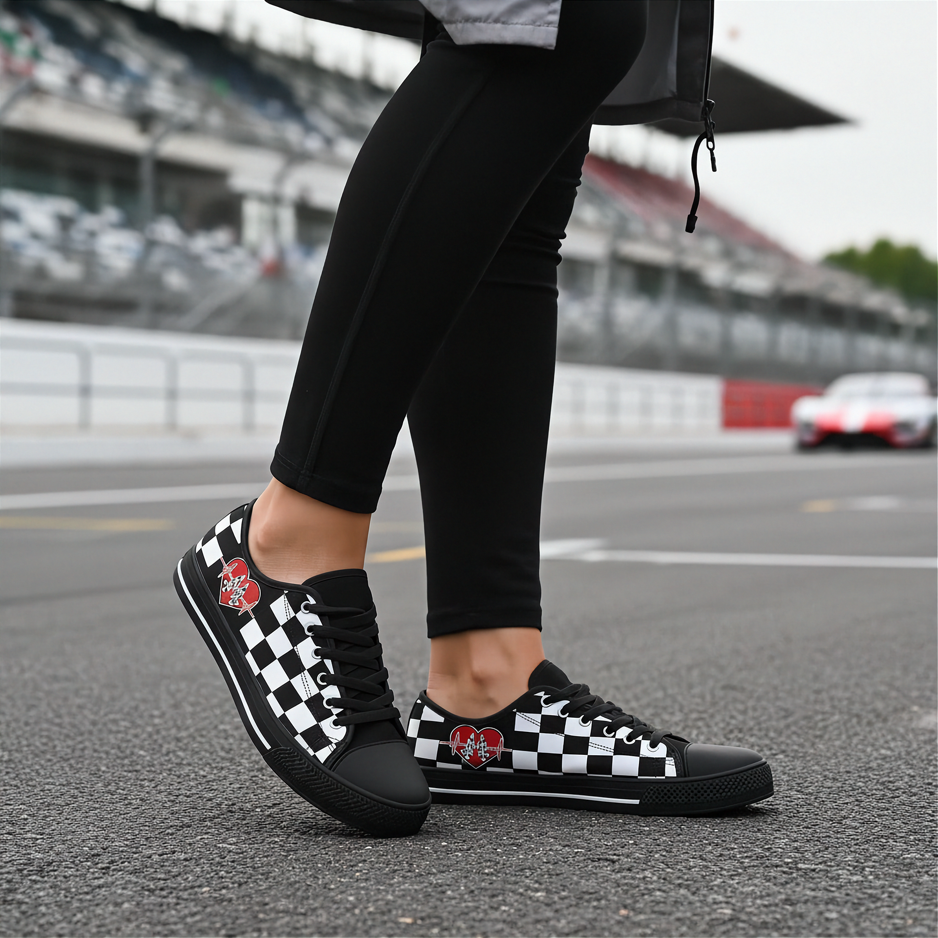 Person wearing black and white checkered low top shoes on a race track.