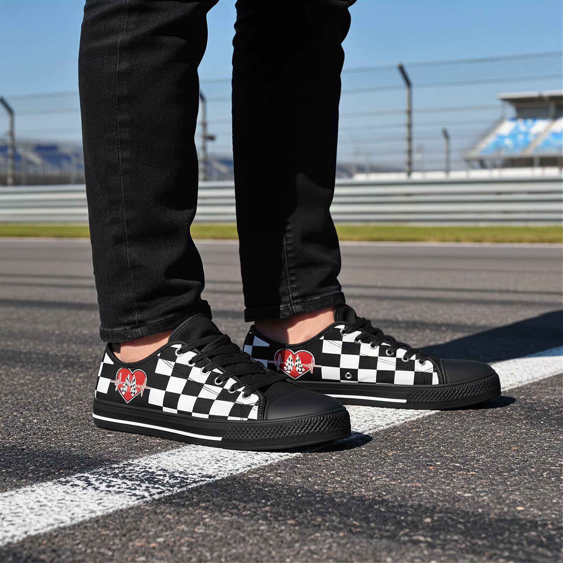 Man wearing a Black checkered low top shoes with red heart designs on a racetrack.