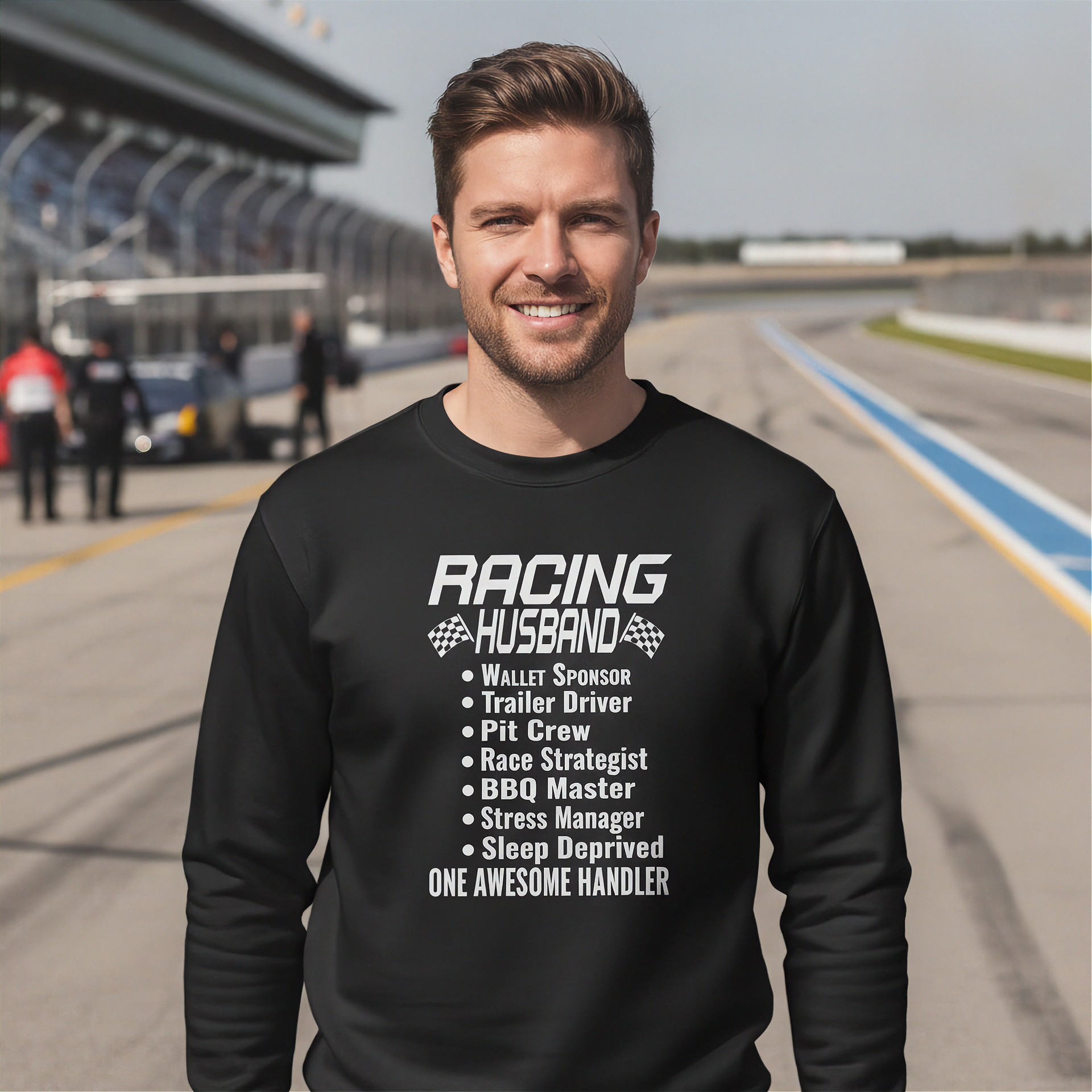 Man wearing a black sweatshirt with 'Racing Husband' text on a race track background