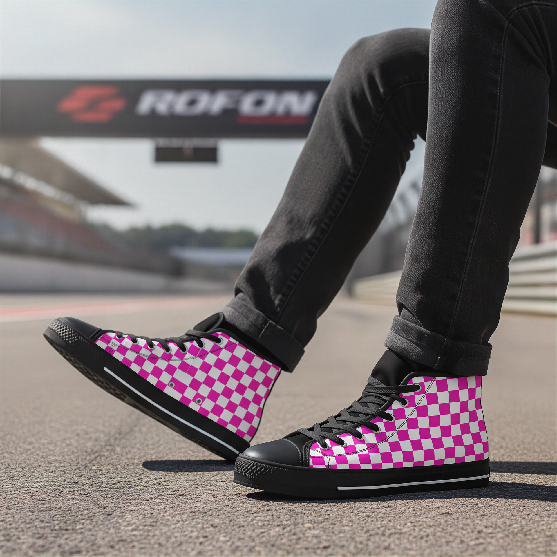 Person wearing pink and black checkered high-top shoes on a race track with 'ROFON' branding in the background.