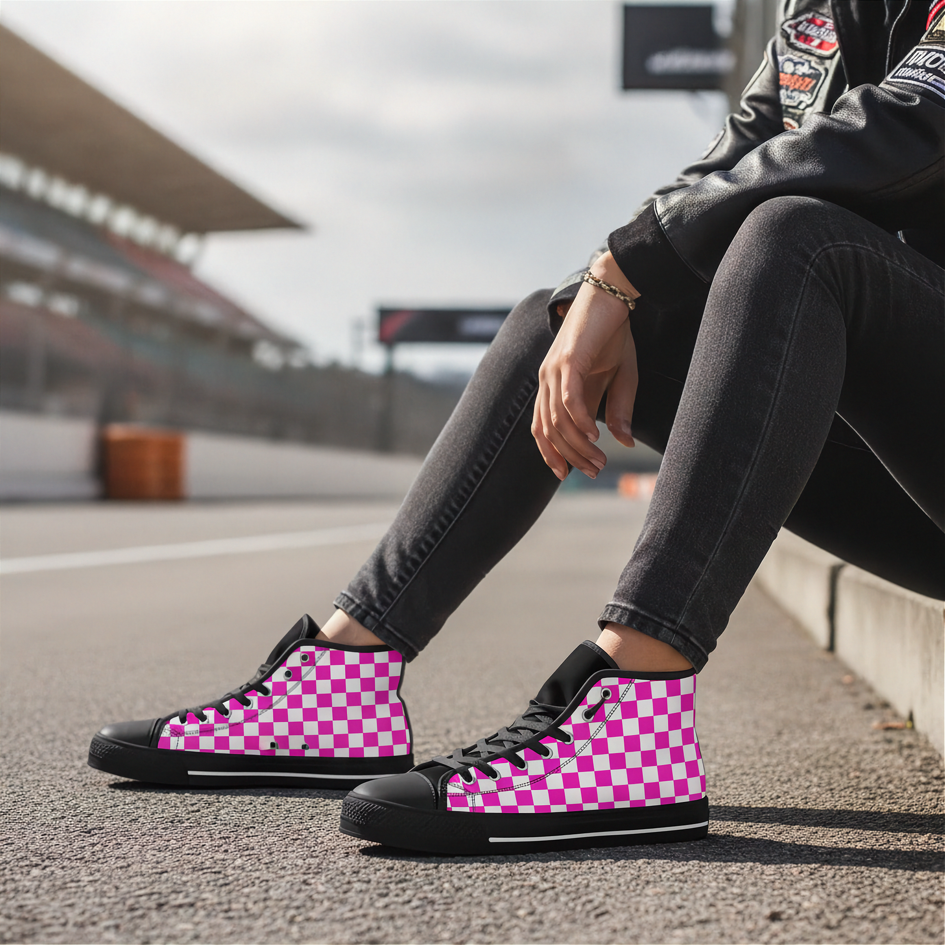 Person wearing pink and black checkered high-top sneakers on a race track.