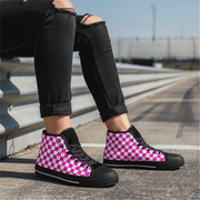 Person wearing pink and black checkered high-top shoes on a road.