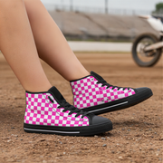 Checkered high-top sneakers on a dirt surface with a blurred background