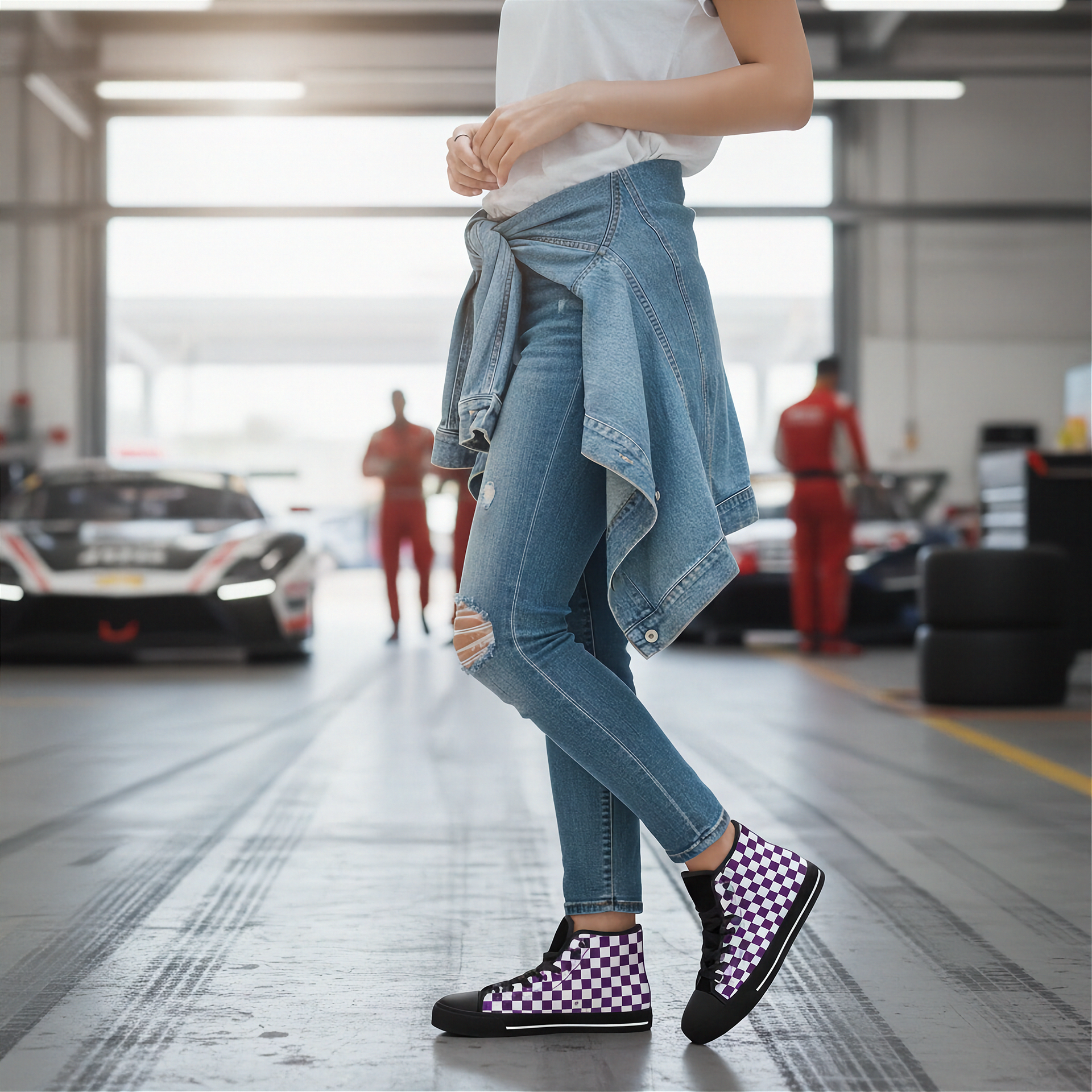 Person wearing checkered shoes in a garage with cars in the background