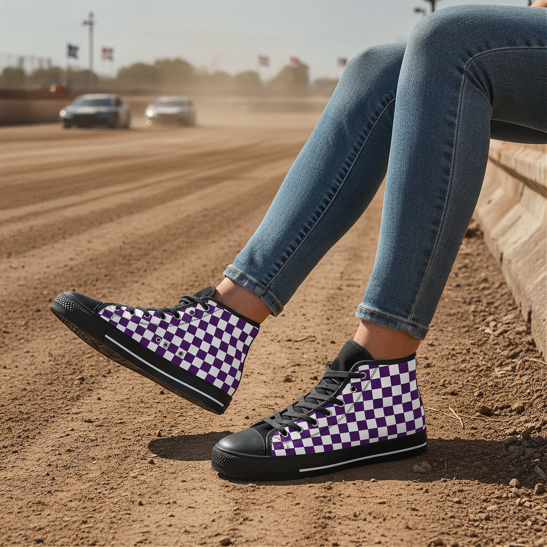 Person wearing purple and white checkered sneakers on a dirt track with cars in the background.