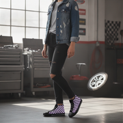 Person wearing a denim jacket, black ripped jeans, and checkered shoes in a garage setting.