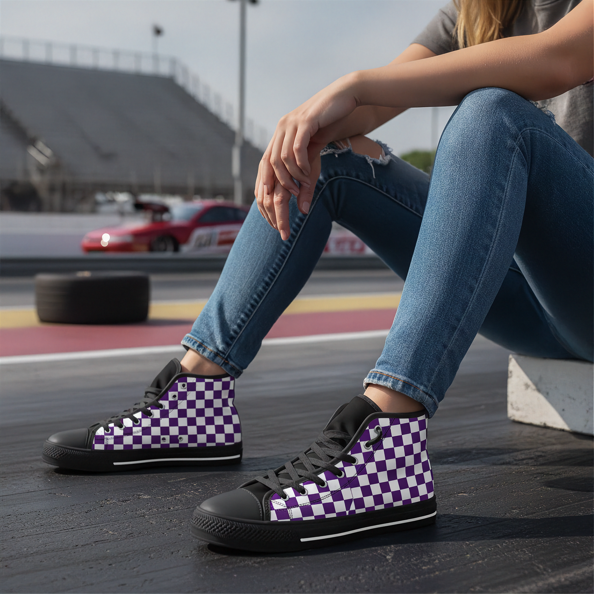 Person wearing purple and white checkered high-top shoes on a race track.