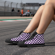 Person wearing purple and white checkered high-top shoes on a race track.