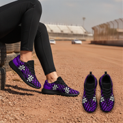 Purple and black athletic sneakers with a white checkerboard pattern on the sides, shown worn on a person's feet and placed on the ground at an outdoor dirt track.