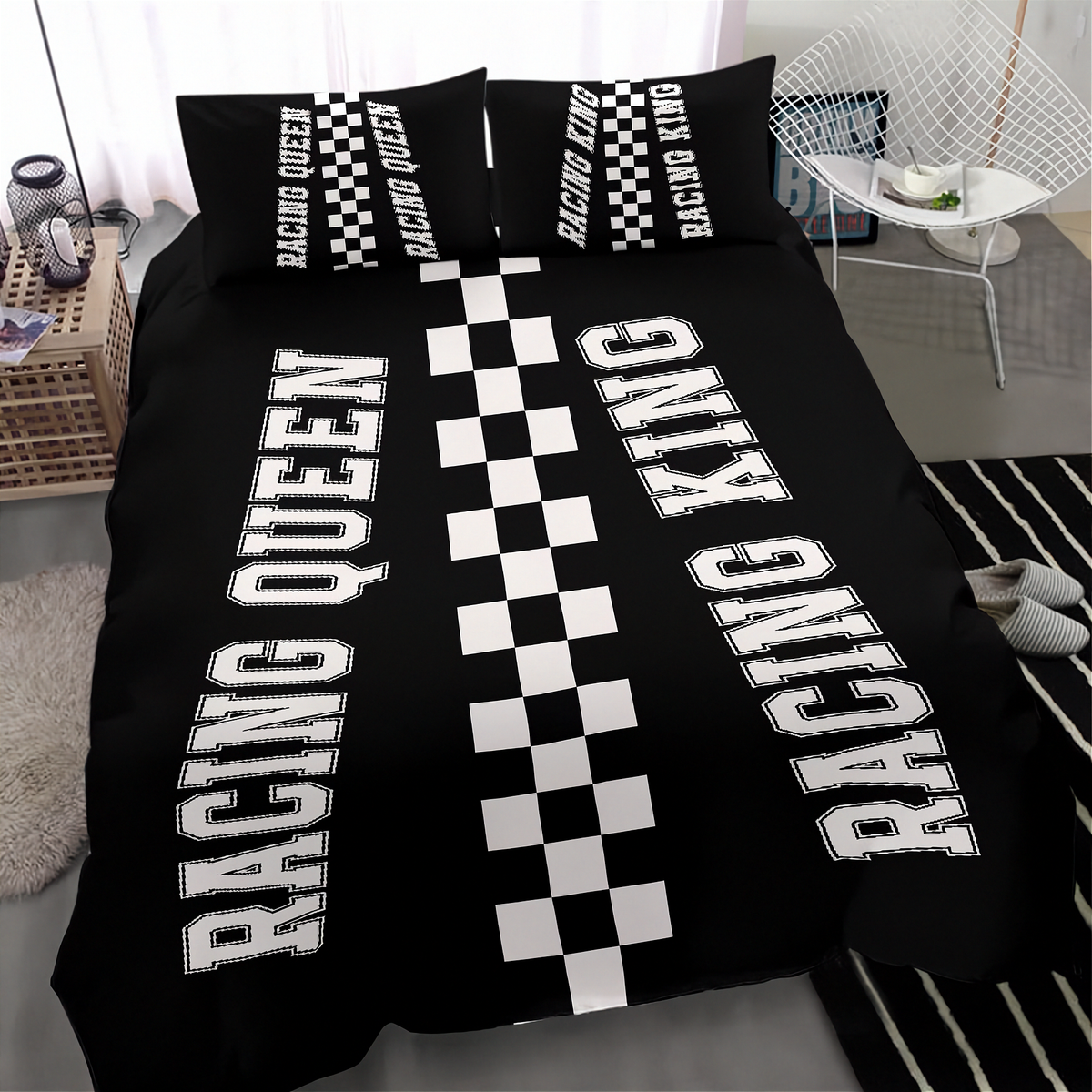 A black bedding set with a racing theme, featuring a duvet cover and two pillowcases with 'RACING QUEEN' and 'RACING KING' printed in white block letters alongside black-and-white checkered stripes, shown in a modern bedroom setting.