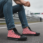 Person wearing red and white checkered shoes with black accents on a road.