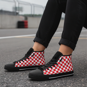 Red and white checkered shoes with black accents worn on a road.