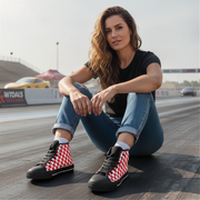 Woman sitting on a race track wearing checkered shoes
