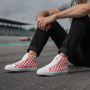 Person wearing red and white checkered high-top shoes on a race track.