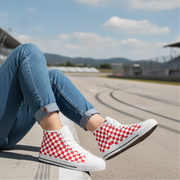 Person wearing red and white checkered high-top shoes on a race track.