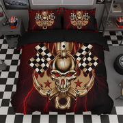 A motorcycle-themed bedding set featuring a duvet cover and two pillowcases with a graphic design of a gold skull, crossed pistons, checkered flags, and red lightning bolts on a black background, displayed in a room with a black-and-white checkered floor.