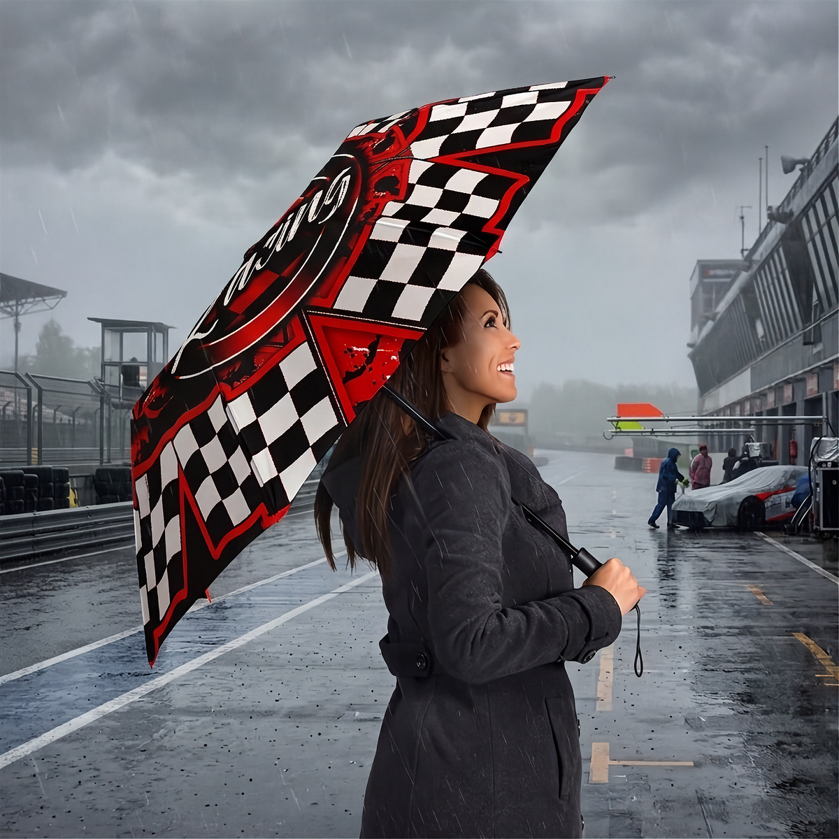 A woman in a dark gray coat stands in the rain at a racetrack holding an open umbrella with a black and white checkered pattern and red accents. The racetrack and grandstands are visible in the background under a cloudy sky.