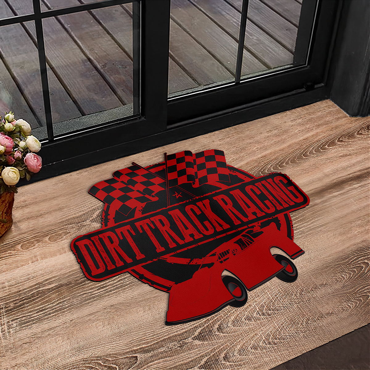 A red and black 'Dirt Track Racing' graphic mat placed on a wooden floor in front of a glass door.