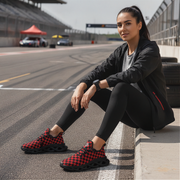 Woman sitting on a race track wearing black and red checkered shoes