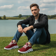 Man sitting by a lake wearing red and black checkered sneakers