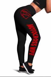 Black high-waisted leggings with red 'MOTOCROSS WIFE' text and a red heart logo on the back hip, shown on a model from the back against a white background.