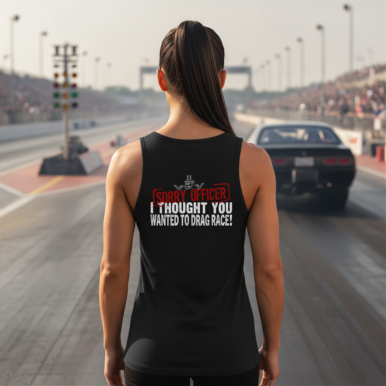 Woman wearing a black tank top with humorous drag racing quote text on a race track