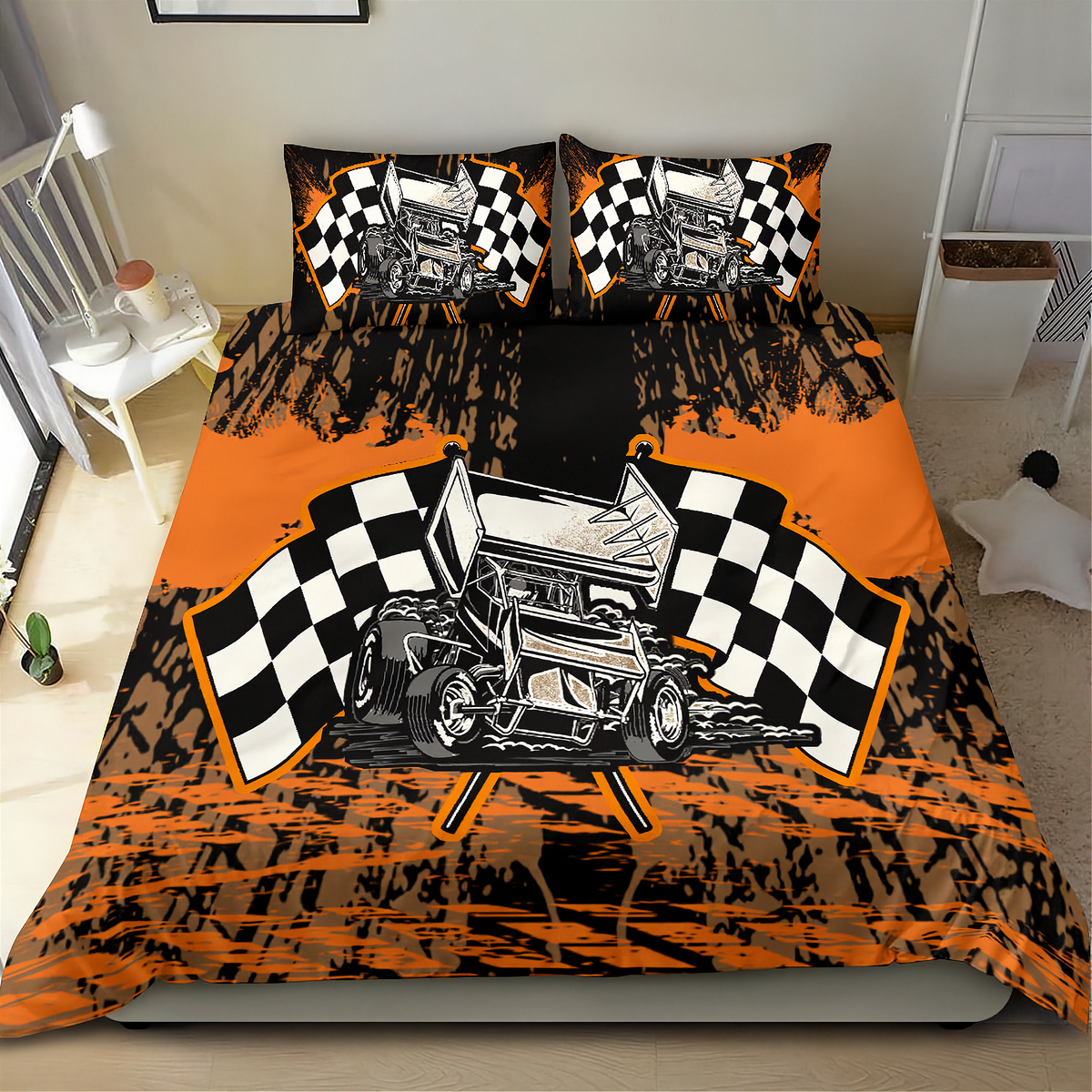 A racing-themed bedding set featuring a duvet cover and two pillowcases with a black and orange paint-splatter design, a vintage race car illustration, and checkered flags, shown on a bed in a bedroom.