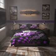 A racing-themed bedding set displayed on a bed in a styled bedroom. The set includes a duvet cover and two matching pillowcases featuring a black and purple checkered pattern, a purple dirt track car graphic, and the text 'Dirt Track Racing'.