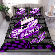 A made bed in a bedroom setting featuring a custom dirt track racing bedding set. The set includes a duvet cover and two matching pillowcases with a graphic design of a purple and white race car, checkered flag patterns, and the text 'DIRT TRACK RACING' on a black and gray background.